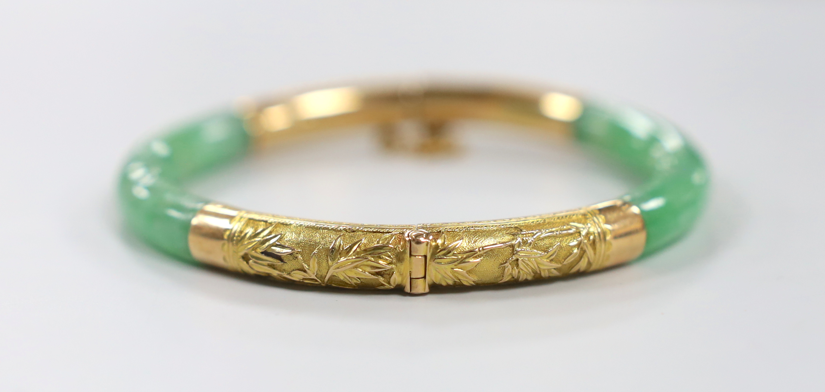 A Chinese 18k yellow metal mounted hinged bangle, interior diameter 57mm, gross weight 29.5 grams.